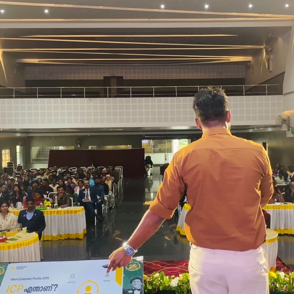 Coach Muhsin presenting Ideal Customer Profile (ICP) sales keynote on stage to packed auditorium in Kerala